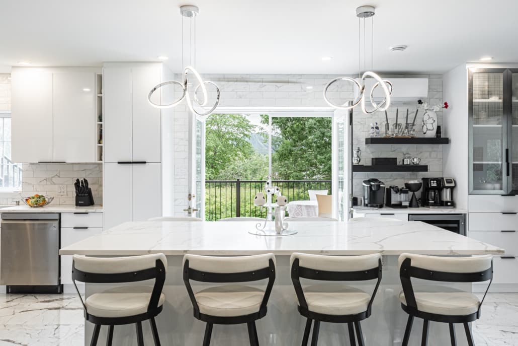 Grande cuisine blanche avec îlot en quartz calacatta et suspensions anneau